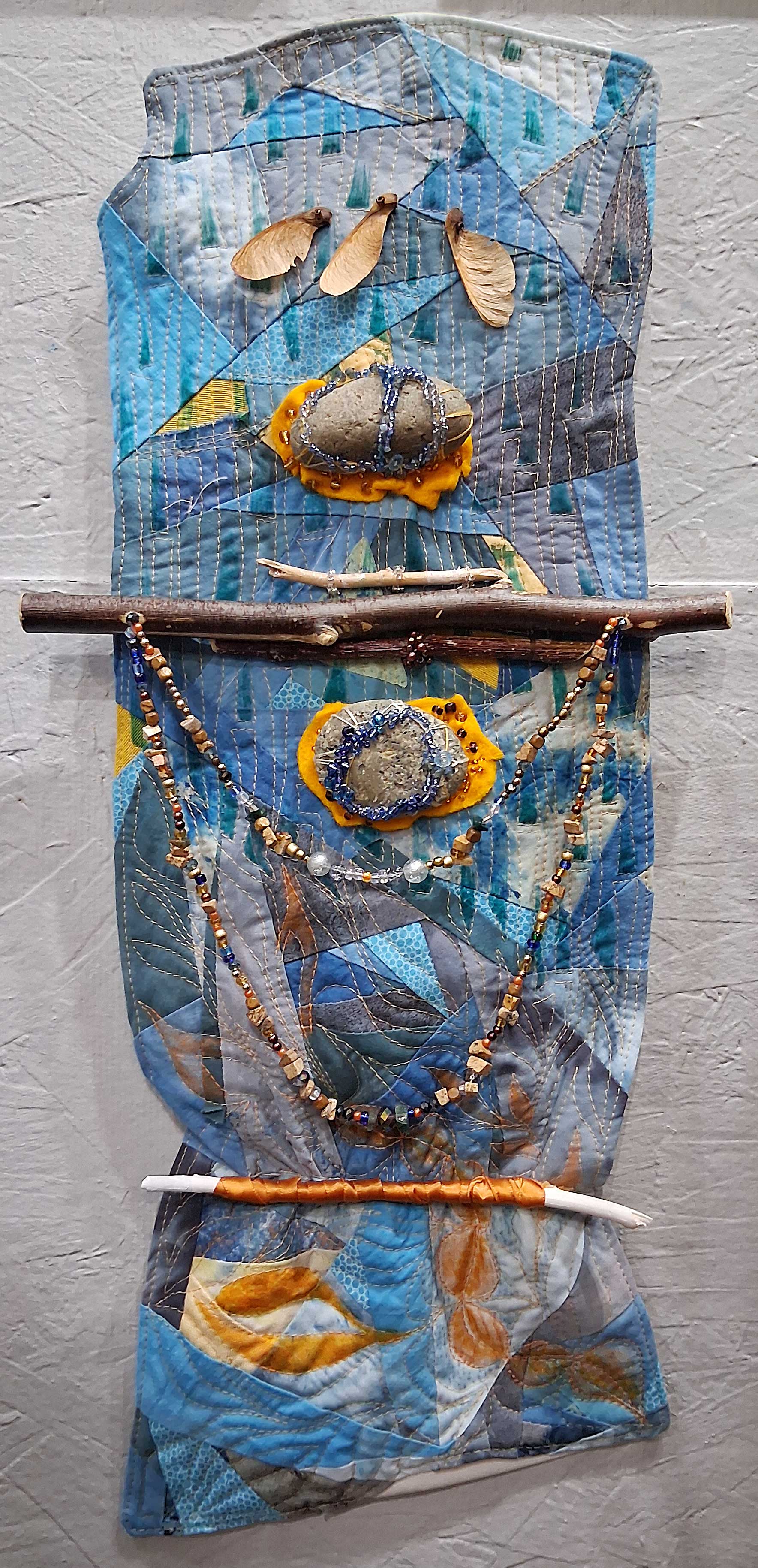stick and stones detail of quilted fiber art wall hanging.